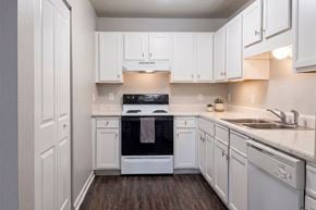 Tulsa apartment for rent - A kitchen with white cabinets and a black oven.