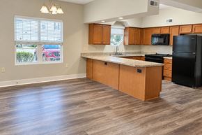 Spiceland apartment for rent - A kitchen with wooden cabinets and a black refrigerator.