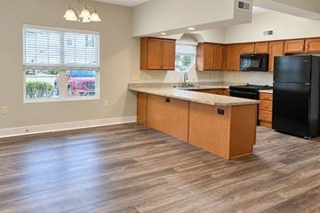 Knightstown apartment for rent - A kitchen with wooden cabinets and a black refrigerator.