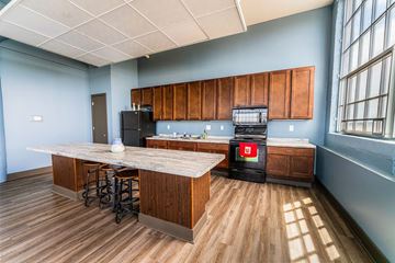 Davenport apartment for rent - A kitchen with wooden cabinets and a black fridge.