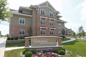 Oconomowoc apartment for rent - A sign for Gateway Luxury Apartments is in front of a building.
