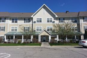 Creston apartment for rent - A large apartment building with a green roof and a white car parked in front.