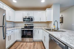 Shawano apartment for rent - A kitchen with white cabinets and a granite countertop.
