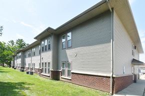 Mahomet apartment for rent - the side of a building with siding and a sidewalk