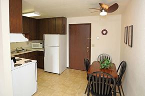 Manitowoc apartment for rent - a kitchen with a dining table and a refrigerator