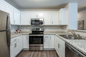 Oshkosh apartment for rent - a kitchen with white cabinets and stainless steel appliances