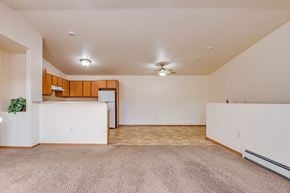 Neenah apartment for rent - A spacious room with a carpeted floor and a ceiling fan.