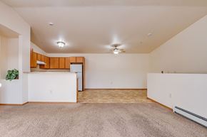 Neenah apartment for rent - A spacious room with a carpeted floor and a ceiling fan.
