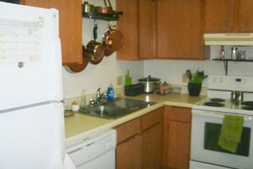 Atlantic apartment for rent - A kitchen with a white refrigerator and wooden cabinets.