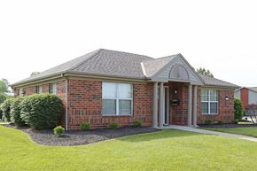 Sidney apartment for rent - A red brick house with a grey roof and a small front yard.