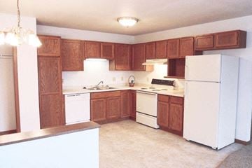 Richland Center apartment for rent - A kitchen with white appliances and wooden cabinets.