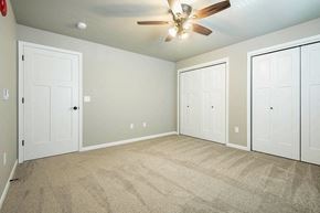 Holmen apartment for rent - an empty bedroom with three doors and a ceiling fan