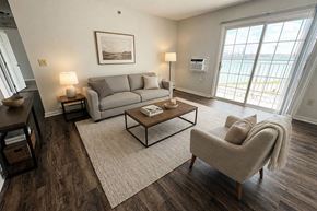 Port Huron apartment for rent - A living room with a grey couch, a coffee table, and a chair.