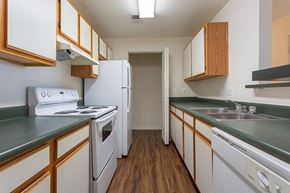 Liberal apartment for rent - a kitchen with white appliances and green counter tops