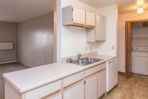 Mitchell apartment for rent - an empty kitchen with a sink and white cabinets