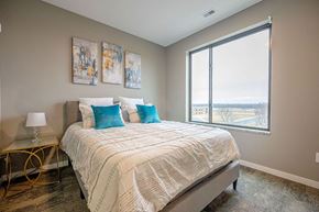 Stewartville apartment for rent - A bedroom with a large bed and a view of the outside.