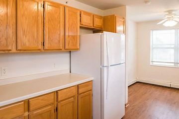 Milwaukee apartment for rent - A kitchen with wooden cabinets and a white refrigerator.