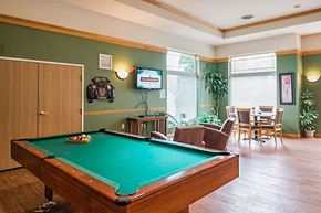 Milwaukee apartment for rent - A pool table is in the middle of a room with a TV mounted on the wall.