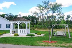 Wisconsin Rapids apartment for rent - a white gazebo in a yard with two benches