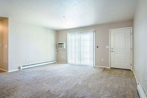 Portage apartment for rent - an empty living room with a white door and a window