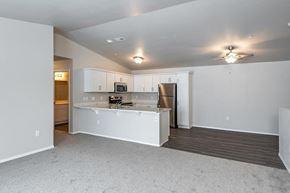 Jackson apartment for rent - an empty living room and kitchen with a refrigerator