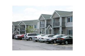 Sheboygan Falls apartment for rent - A parking lot with cars and apartment buildings in the background.