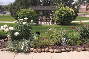 Muskego apartment for rent - A garden with a bench and a gazebo.