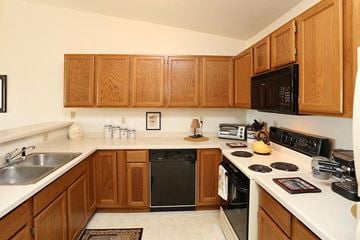 Neenah apartment for rent - a kitchen with a stove top oven and a sink