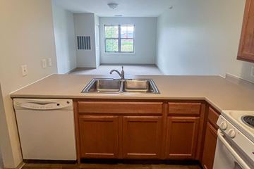 Dubuque apartment for rent - A kitchen with wooden cabinets and a white dishwasher.