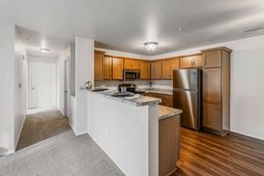 Plover apartment for rent - A kitchen with a white island and wooden cabinets.