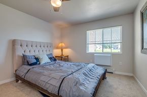 Shawano apartment for rent - A bedroom with a large bed and a ceiling fan.