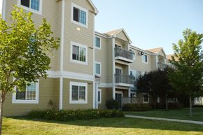 Carroll apartment for rent - an apartment building with a grass yard and trees