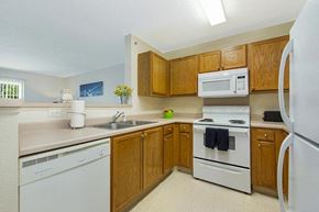 Le Claire apartment for rent - a kitchen with white appliances and wooden cabinets