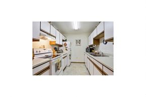 Marinette apartment for rent - a kitchen with white appliances and wooden cabinets
