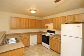Platteville apartment for rent - a kitchen with white appliances and wooden cabinets