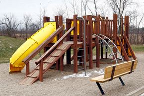 Napoleon apartment for rent - a playground with a yellow slide and wooden benches