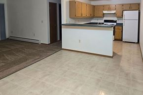 Greenville apartment for rent - A kitchen with white appliances and wooden cabinets.
