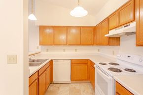 Milton apartment for rent - a kitchen with white appliances and wooden cabinets