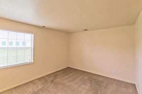 Paris apartment for rent - an empty bedroom with a large window and carpet
