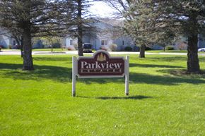 Waseca apartment for rent - a park sign in the grass in front of a house
