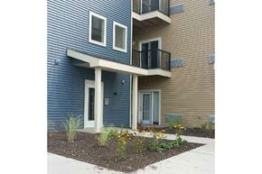 Viroqua apartment for rent - a blue house with a balcony and a sidewalk