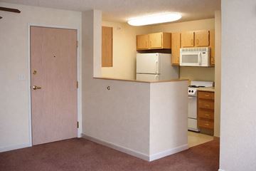 Creston apartment for rent - A kitchen area with a refrigerator, microwave, and oven.