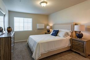 Beaver Dam apartment for rent - A bedroom with a bed, nightstand, and two lamps.