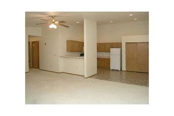Green Bay apartment for rent - A kitchen with a refrigerator, cabinets, and a ceiling fan.