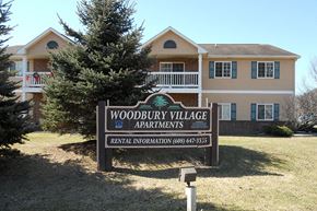 Richland Center apartment for rent - A sign for Woodbury Village Apartments in front of a building.
