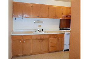 Depere apartment for rent - an empty kitchen with wooden cabinets and a sink