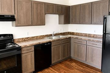 Northfield apartment for rent - A kitchen with wooden cabinets and black appliances.