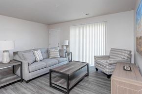 Waterford apartment for rent - A living room with a grey couch, a chair, and a coffee table.