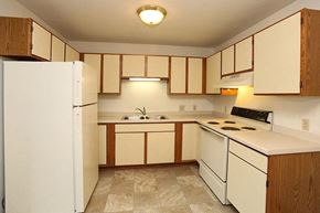 Stevens Point apartment for rent - a kitchen with white appliances and wooden cabinets