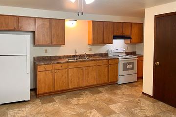 Sturgeon Bay apartment for rent - A kitchen with wooden cabinets and a white refrigerator.